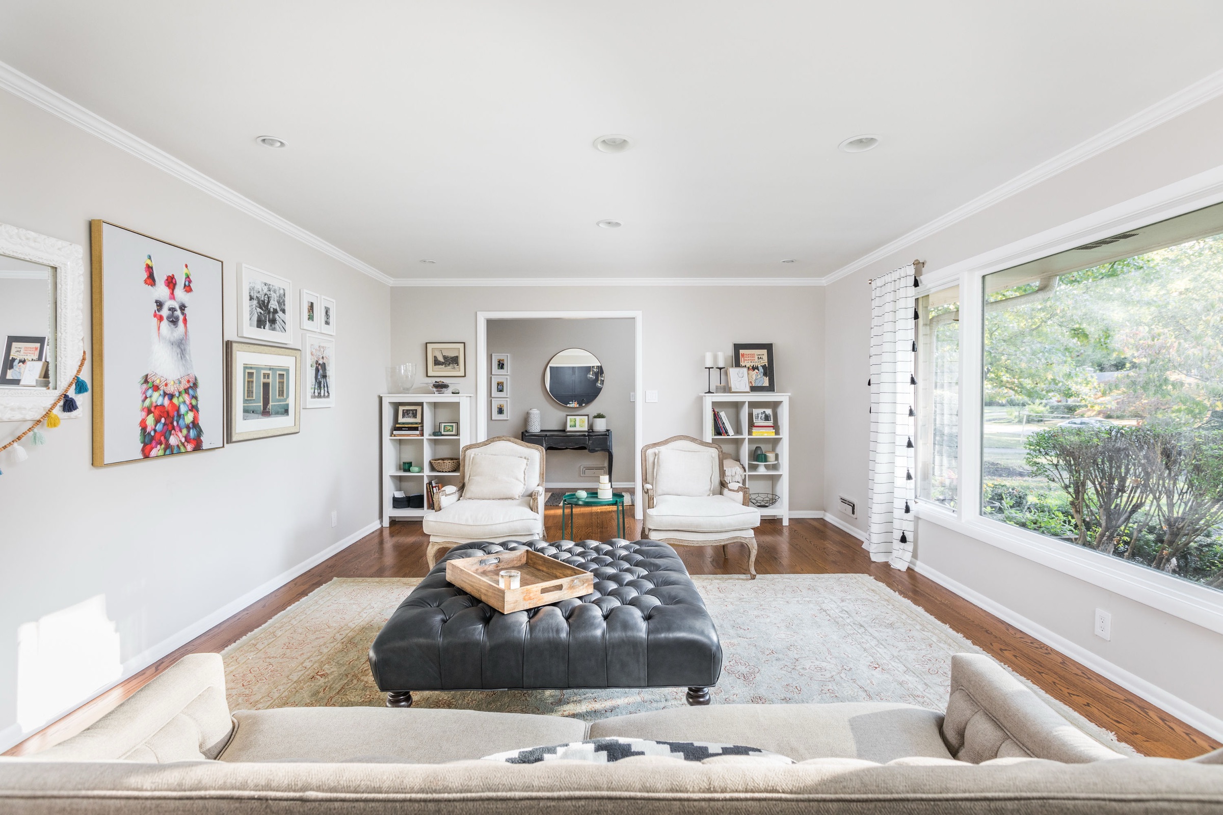 Personality-filled living room with gallery wall and tufted ottoman
