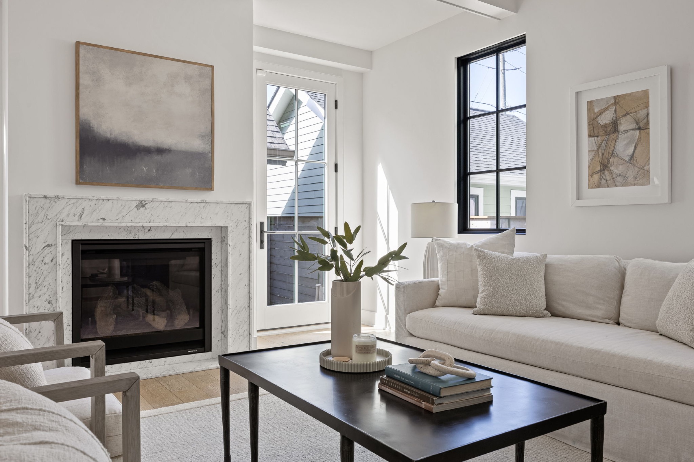 Staged living room with marble fireplace and neutral sofa